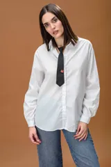 Camisa blanca de corte oversize, con cuello clásico, cierre frontal de botones y mangas largas con puños abotonados.