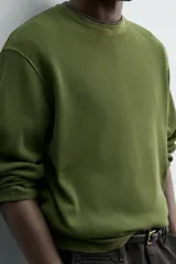 Remera de manga larga en tejido waffle de algodón color verde militar, con cuello redondo y corte relajado.
