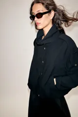 Chaqueta oversize de modal con cuello subido, cierre frontal con botones a presión y mangas largas con puños elásticos. Presenta trabillas en los hombros, bolsillos de vivo en el delantero y bajo abullonado con elástico.