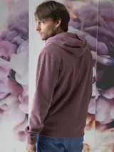 Buzo tipo hoodie con cierre frontal completo, capucha con cordones ajustables y bolsillos laterales. Confeccionado en tejido de algodón con textura jaspeada.