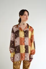 Camisa de seda fluida con estampado de parches en tonos marrones, amarillos y rosas.