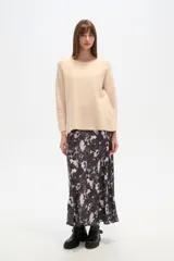 Sweater negro liso, holgado, con cuello a la base y broches decorativos en el lateral.