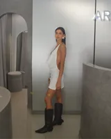 Minivestido blanco de tejido de punto calado, con escote halter y espalda descubierta.