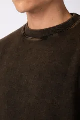 Buzo de cuello redondo con efecto desgastado, de calce oversize y mangas largas. Presenta un pequeño logo estampado en la parte inferior frontal y una etiqueta pequeña en el puño.