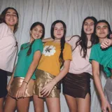 Remera verde de algodón de manga corta con aplique de alas doradas en el pecho.