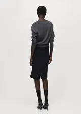 Cardigan de punto fino con cuello en pico y cierre frontal de botones. Presenta un diseño recto de manga larga, confeccionado en lana.