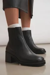 Botas de cuero color beige con elástico en los laterales, taco de madera y suela de goma.