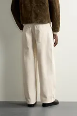 Pantalón relaxed fit negro confeccionado en tejido de algodón con estructura diagonal, estilo de cinco bolsillos y cierre frontal con cremallera y botón metálico.