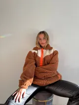 Canguro de polar color marrón chocolate con detalles en blanco y naranja.