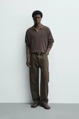 Pantalón cargo straight fit de algodón color negro con efecto lavado, bolsillos laterales en las piernas y cierre frontal con cremallera y botón.