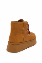 Bota corta de gamuza sintética color marrón chocolate, con plataforma chunky de goma y sistema de cordones trenzados con ganchos metálicos.