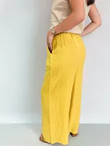 Pantalón palazzo amarillo de lino con cintura elástica y cordón ajustable.