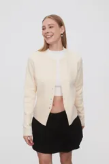 Saco negro de punto, con cuello redondo a la base, manga larga y cierre frontal con botones.