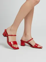 Sandalias rojas de taco medio, con punta cuadrada y dos tiras en el empeine, una fina y otra más ancha con textura.