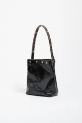 Bolso de hombro Bimba y Lola de tamaño mediano, confeccionado en piel vacuna con acabado brillante efecto arrugado. Presenta un diseño estructurado con asa larga decorada con tachas metálicas plateadas y cierre mediante botón de presión.