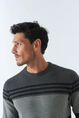 Sweater de punto a rayas horizontales en colores mostaza, blanco y azul marino, con cuello redondo y puños ajustados.