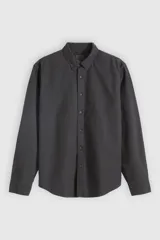 Camisa de manga larga color negro lavado, con cuello camisero con botones y cierre frontal abotonado.
