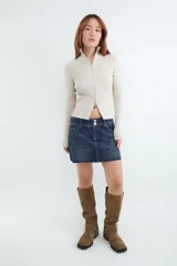 Sweater de punto celeste con diseño acanalado, cuello alto y cierre frontal con doble cremallera metálica, de manga larga y calce al cuerpo.