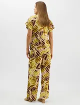 Conjunto de dos piezas confeccionado en mezcla de algodón y lino, con estampado abstracto en tonos verde y borravino. Incluye una blusa de manga corta con escote en V y cierre frontal con un botón, y un pantalón de tiro alto y pierna recta con bolsillos laterales.