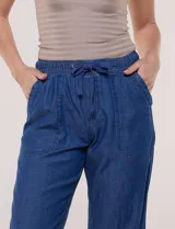 Pantalón de lino de calce holgado y caída ligera, con estampado de rayas verticales en tonos celestes y blancos. Cuenta con cintura elastizada fruncida con cordón ajustable al frente, bolsillos laterales y pierna recta.