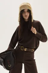 Polera de tejido de punto en color marrón chocolate, con cuello alto y mangas largas de corte holgado.