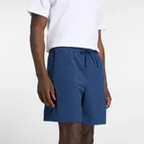 Short deportivo New Balance azul marino, con bolsillos laterales y logotipo reflectante de la marca.
