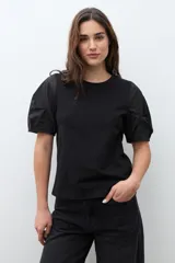 Remera negra de algodón con cuello redondo y mangas cortas abullonadas con detalle de frunces.