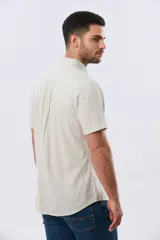 Camisa de manga corta confeccionada en mezcla de lino y algodón, con diseño de rayas verticales en tonos celeste y blanco. Cuenta con cuello camisero, botonadura frontal y bordado sutil en el pecho.