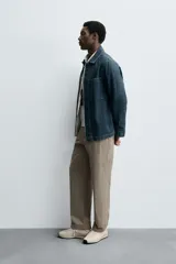 Pantalón de corte recto confeccionado en tejido de algodón con estructura twill, con bolsillos frontales y bolsillos traseros de vivo con botón.