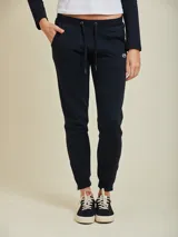 Pantalón tipo babucha de algodón y poliéster, color negro, con cintura elástica ajustable mediante cordón, bolsillos laterales y puños en los tobillos.
