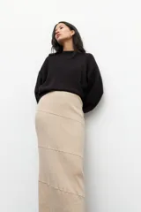 Falda larga de punto color negro, de corte ajustado al cuerpo, con diseño de costuras horizontales y diagonales que crean un efecto de paneles.