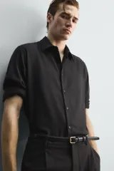 Camisa de corte relajado confeccionada en una mezcla de lana y viscosa. Presenta cuello clásico, manga larga con puños abotonados y cierre frontal con botones a tono.