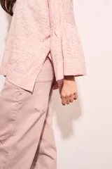 Sweater de punto con efecto jaspeado, de corte oversize, cuello redondo y mangas largas con terminación acampanada tipo volado.