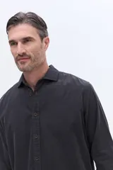 Camisa de pana de algodón con cuello clásico, cierre frontal de botones y mangas largas. Presenta un diseño de corte regular con textura suave y acabado mate.