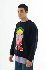 Buzo negro de algodón con cuello redondo y puños acanalados. Estampado frontal con un personaje de caricatura y el texto "HOME ALONE" en verde.