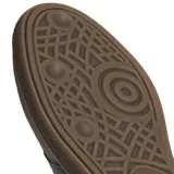 Championes Adidas modelo Handball Spezial, de diseño retro inspirado en los años 70. Confeccionados en una combinación de gamuza y cuero en tonos marrones, presentan las icónicas tres bandas laterales en un tono más oscuro, detalle de logo dorado en el lateral y suela de caucho color caramelo.