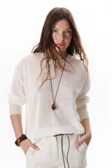 Sweater beige de tejido fino y mangas largas.