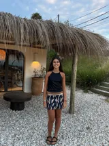 Minifalda dorada de cuero sintético, corte medio/bajo, con cortes en el delantero y pequeño tajo a un lado.