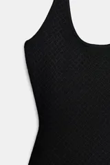 Vestido largo negro de cuello halter, espalda descubierta y escote redondo. Presenta un diseño de punto combinado en la parte superior y una falda larga de tejido fluido.