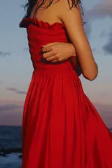 Vestido midi rojo en mezcla de viscosa, con cuerpo fruncido tipo nido de abeja, escote recto, tirantes finos ajustables con moñas y falda amplia con vuelo.