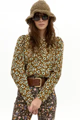 Blusa de corduroy de algodón con estampado floral en tonos mostaza y crudo, cuello a la base y mangas largas con hombros abullonados.