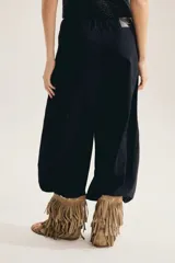 Pantalon balloon color negro, de tiro alto con cintura elastizada, corte amplio y volumen bombacho que se angosta hacia los tobillos.
