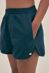 Short azul marino confeccionado en tejido seersucker de algodón con cintura elastizada, bolsillos laterales y detalle de logo metálico.
