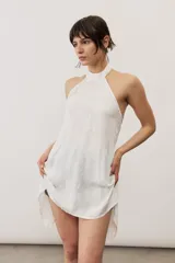 Top halter celeste con diseño asimétrico de corte más largo en la parte trasera, cuello alto y sutil estampado floral.