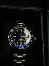 Reloj Rolex Submariner "Batman" con bisel giratorio unidireccional negro y azul, esfera negra con índices luminiscentes, lupa sobre la ventana de fecha y malla de acero inoxidable.