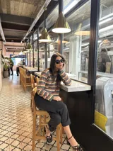 Sweater de hilo con lurex a rayas horizontales en tonos verde, azul y gris. Diseño crop oversize con calce relajado y hombro caído.