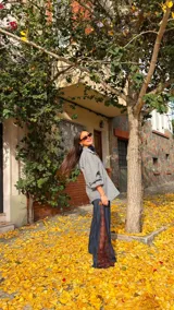 Camisa de corte oversize con estampado de cuadros en tonos grises. Presenta cuello camisero, mangas largas abullonadas y cierre frontal con botones.