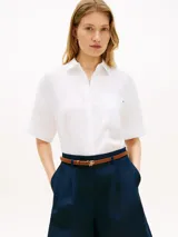 Camisa de manga corta Tommy Hilfiger confeccionada en puro lino blanco, con corte amplio, cuello inglés, hombros ligeramente caídos y un bolsillo de parche en el pecho con el logo bordado.