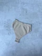 Bombacha de bikini color beige, de tiro alto y corte vedetina.