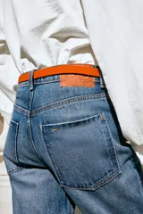 Jeans de tiro alto y corte recto de pernera larga, con diseño clásico de cinco bolsillos y costuras en contraste. Cierre frontal con cremallera y botón metálico.